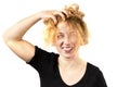 Close-up of a disheveled girl, laughing, holding her head and smoothing her hair. Isolated on a white background. The