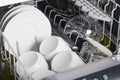 Close-up, in the dishwasher, clean plates, mugs, glasses and a knife, after work