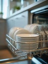Close-up of a dishwasher rack filled with clean white plates and neatly arranged silverware in a modern kitchen setting with soft Royalty Free Stock Photo