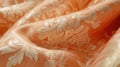 A close-up display of a Peach Fuzz brocade fabric, focusing on the rich, decorative patterns and soft peach color, fully Royalty Free Stock Photo
