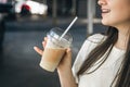 Close-up, disposable cup of iced coffee in female hands. Royalty Free Stock Photo