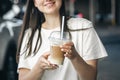 Close-up, disposable cup of iced coffee in female hands. Royalty Free Stock Photo