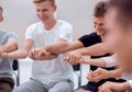 Close up. diverse young people taking each other`s hands Royalty Free Stock Photo