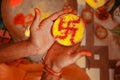 Close up of diyas or divas of brown color with a swastik or Swastika drawn in it and hold on hand