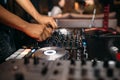 Close up of DJ`s hand playing music at turntable on a party festival - Portrait of DJ mixer audio in a beach club above the crowd