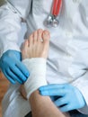 Close up of doctor bandaging one injured foot