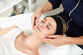 Doctor-cosmetologist hands massaging the face of relaxed young woman. Face lifting anti-aging massage. Professional lymphatic Royalty Free Stock Photo