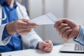 Close up of doctor giving prescription paper to patient at checkup appointment Royalty Free Stock Photo