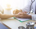 Close up of doctor hand reassuring her female patient at hospital. Closeup hands of medical doctor carefully holding patient Royalty Free Stock Photo