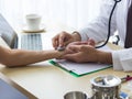 Close up doctor hand reassuring her female patient at hospital. Closeup hands of medical doctor carefully holding patient`s Royalty Free Stock Photo