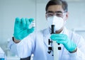 Close up of doctor hand wearing blue disposable gloves and showing vaccine phial for coronavirus covid-19. Detail of hand with Royalty Free Stock Photo