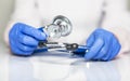 Close up of doctor hands in gloves with stethoscope, medical exam concept Royalty Free Stock Photo