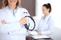 Close up of a doctor holding a stethoscope in his hand while standing in medical office Royalty Free Stock Photo