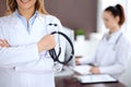 Close up of a doctor holding a stethoscope in his hand while standing in medical office Royalty Free Stock Photo