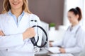 Close up of a doctor holding a stethoscope in his hand while standing in medical office Royalty Free Stock Photo