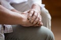 Close up doctor holding wrinkled hands of elder male patient.