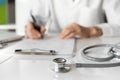 Close-up of doctor medical professional wearing uniform taking notes, physician or therapist  filling medical document Royalty Free Stock Photo