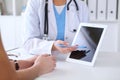 Close up of a doctor and patient hands while phisician pointing into tablet computer monitor