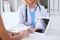 Close up of a doctor and patient hands while phisician pointing into tablet computer monitor