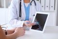 Close up of a doctor and patient hands while phisician pointing into tablet computer monitor