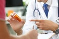 Close-up of doctor`s hand holding medicine and giving it to his patient. Royalty Free Stock Photo