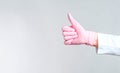 Close-up doctor`s hand in pink rubber gloves shows OK sign on grey background Royalty Free Stock Photo