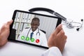 Doctor Video Conferencing With Male Colleague On Digital Tablet