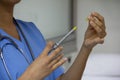 Close-up of a doctor's hands holding a syringe. Portrait without face with stethoscope and light blue uniform Royalty Free Stock Photo