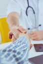 Close up of a male doctor shaking hands with his male patient. Medicine and trust concept