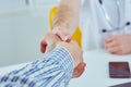 Close up of a male doctor shaking hands with his male patient. Medicine and trust concept Royalty Free Stock Photo