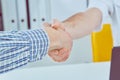 Close up of a male doctor shaking hands with his male patient. Medicine and trust concept