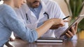 Close up doctor therapist consulting female patient, using tablet Royalty Free Stock Photo