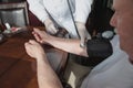 Close-up of a doctor using a stethoscope on an elderly person`s elbow to measure blood pressure. A gerontologist monitors the Royalty Free Stock Photo