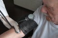 Close-up of a doctor using a stethoscope on an elderly person`s elbow to measure blood pressure. A gerontologist monitors the Royalty Free Stock Photo