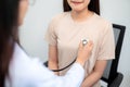 Close up of doctor using stethoscope putting beat heart diagnose with patient in examination room at a hospital. Medical and