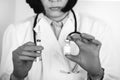 Close up of a doctor in white lab coat and sterile gloves holding syringe and medicine in ampoule
