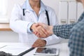 Close up of a doctor woman shaking hands with her male patient. Medicine and trust concept Royalty Free Stock Photo