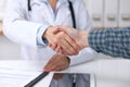 Close up of a doctor woman shaking hands with her male patient. Medicine and trust concept Royalty Free Stock Photo