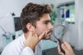 Close-up doctors hands checking mans moles