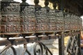 CLOSE UP: Beautiful metal prayer wheels are illuminated by the bright sunshine