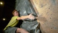 CLOSE UP: Climber reaches up to grip a hold while training at indoor center. Royalty Free Stock Photo