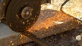 CLOSE UP: Contractor cuts into two rusty metal rods with an angle grinder. Royalty Free Stock Photo