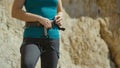 CLOSE UP: Female rock climber fastens the harness around her waist before ascent Royalty Free Stock Photo
