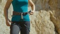 CLOSE UP Female rock climber tightens the harness around her waist before ascent Royalty Free Stock Photo