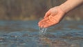 CLOSE UP: Glistening river water flowing out of unknown gentle woman\'s hand.