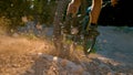 CLOSE UP, DOF: Mountain biker kicking up dust and rocks while braking hard Royalty Free Stock Photo