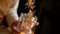 CLOSE UP: Unrecognizable cobbler dropping wooden tacks into an empty glass jar.