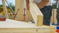 CLOSE UP: Unrecognizable male builder picks up a CLT beam from a workbench. Royalty Free Stock Photo