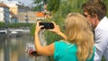 CLOSE UP: Unrecognizable blonde woman taking photos of the river with smartphone Royalty Free Stock Photo