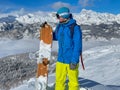 COPY SPACE, DOF: Young man observes the wintry mountains before snowboarding. Royalty Free Stock Photo